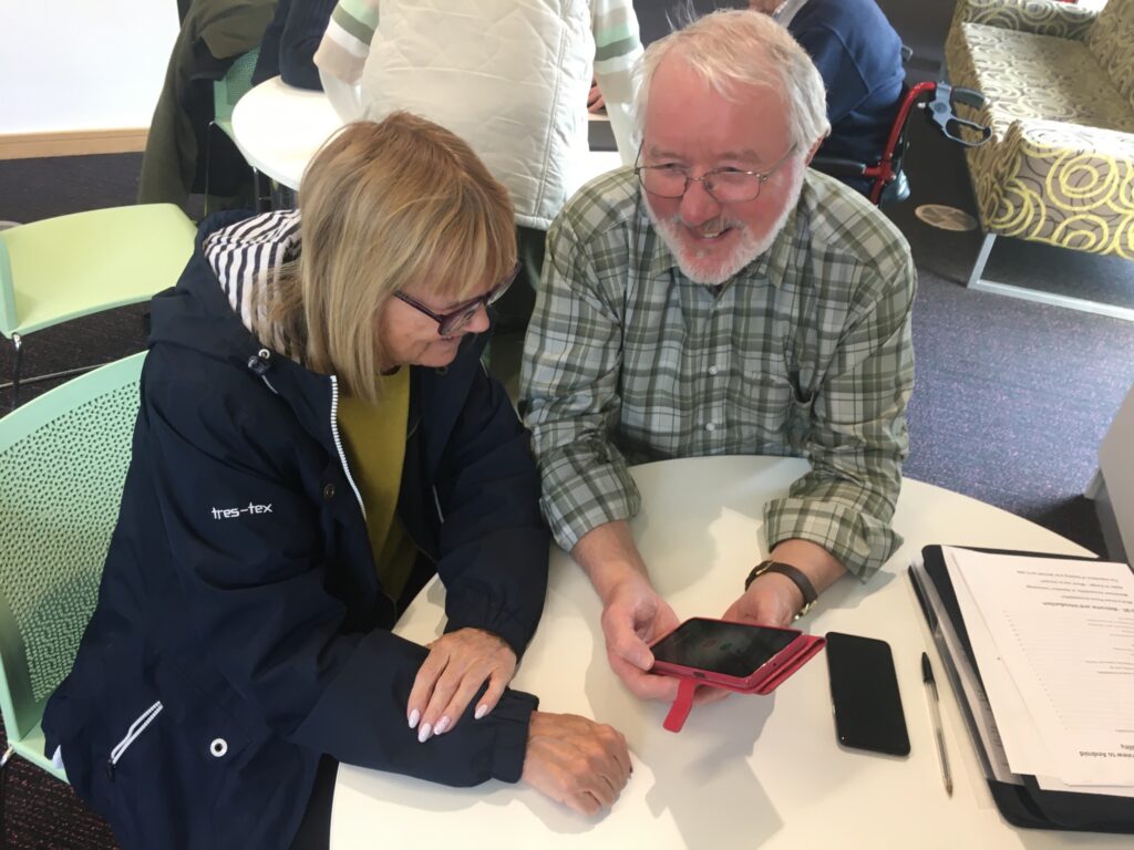 Tech Trainer demonstrating smart phone functions to a client