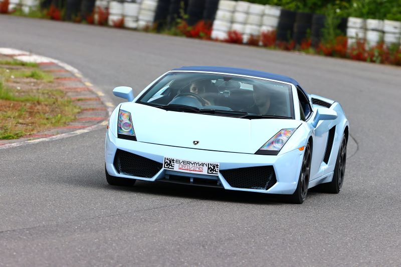 A young visually impaired person driving a specially adapted blue Lamborghini