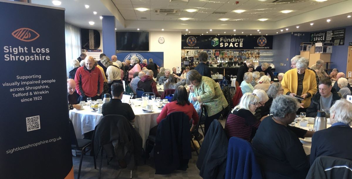 A large group of people seated around tables and chatting at a Winters Day Out