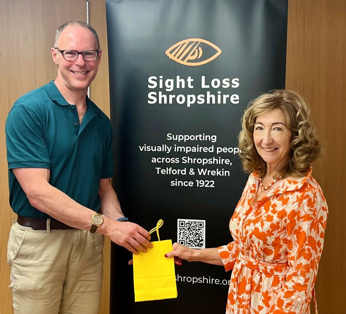 Daniel being handed a leaving gift by SLS President Jenny