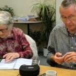 A group sight loss training session with people trying out magnification aids