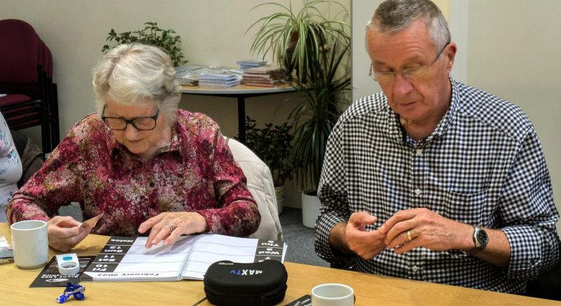 A group sight loss training session with people trying out magnification aids