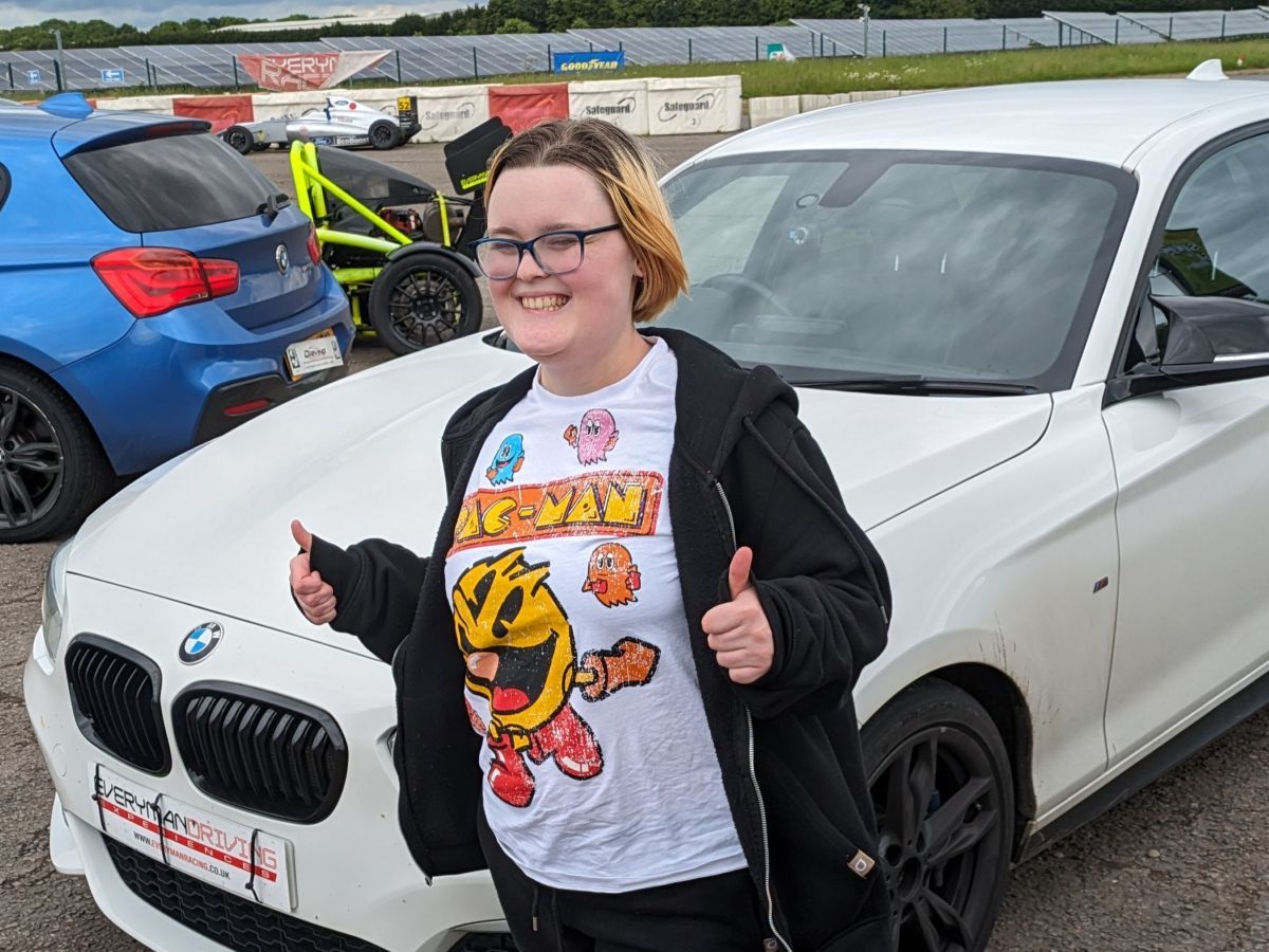 A female teen enjoying a supercar experience.