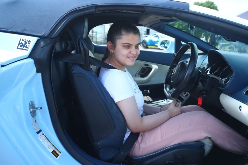 Visually impaired young woman enjoying a supercar driving experience