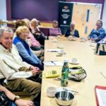 A group sight loss training session with people sitting around a large table