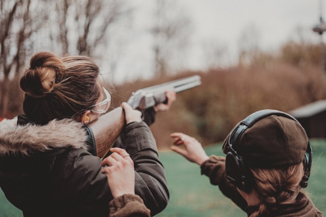 Two people aiming rifles at a shooting range