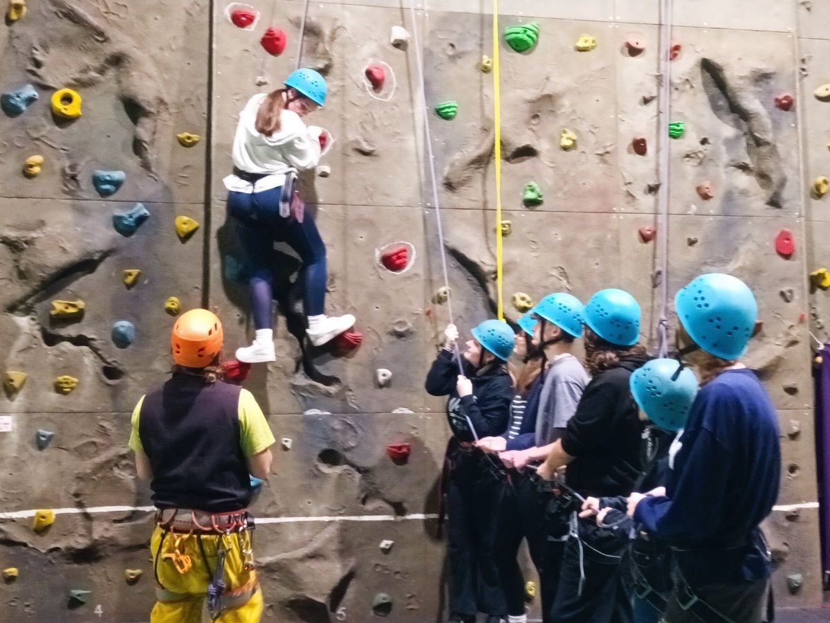 Young people using an indoor climbing wall
