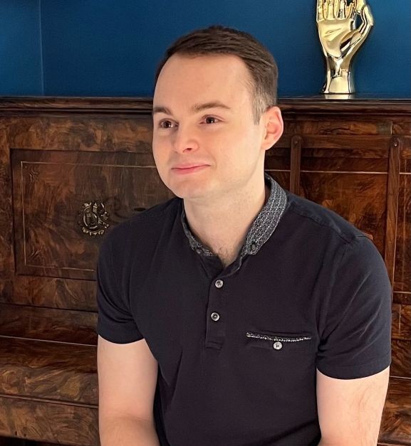 A young man wearing a black polo top