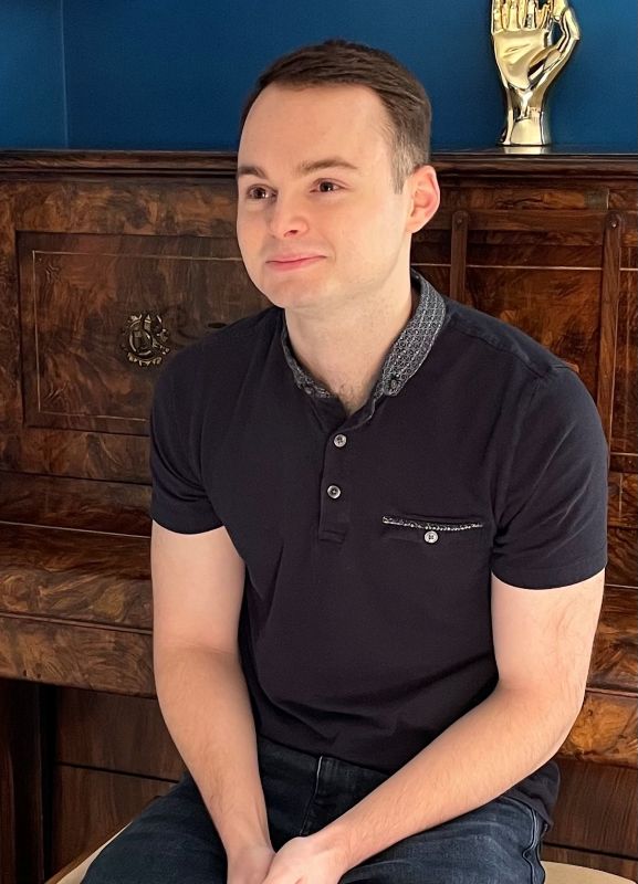 James A young man wearing a black polo top