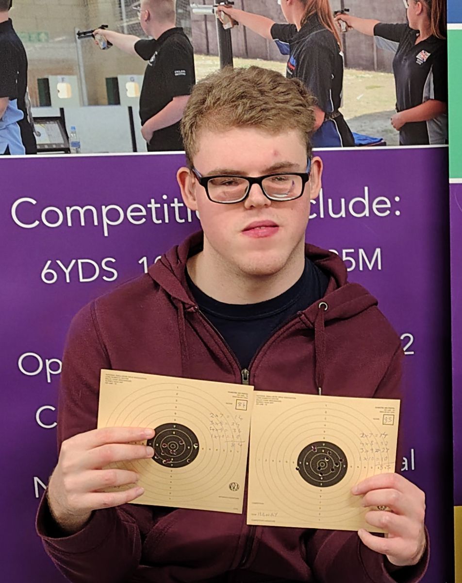 Rifle Shooting Day A young man holds targets at a rifle shooting experience