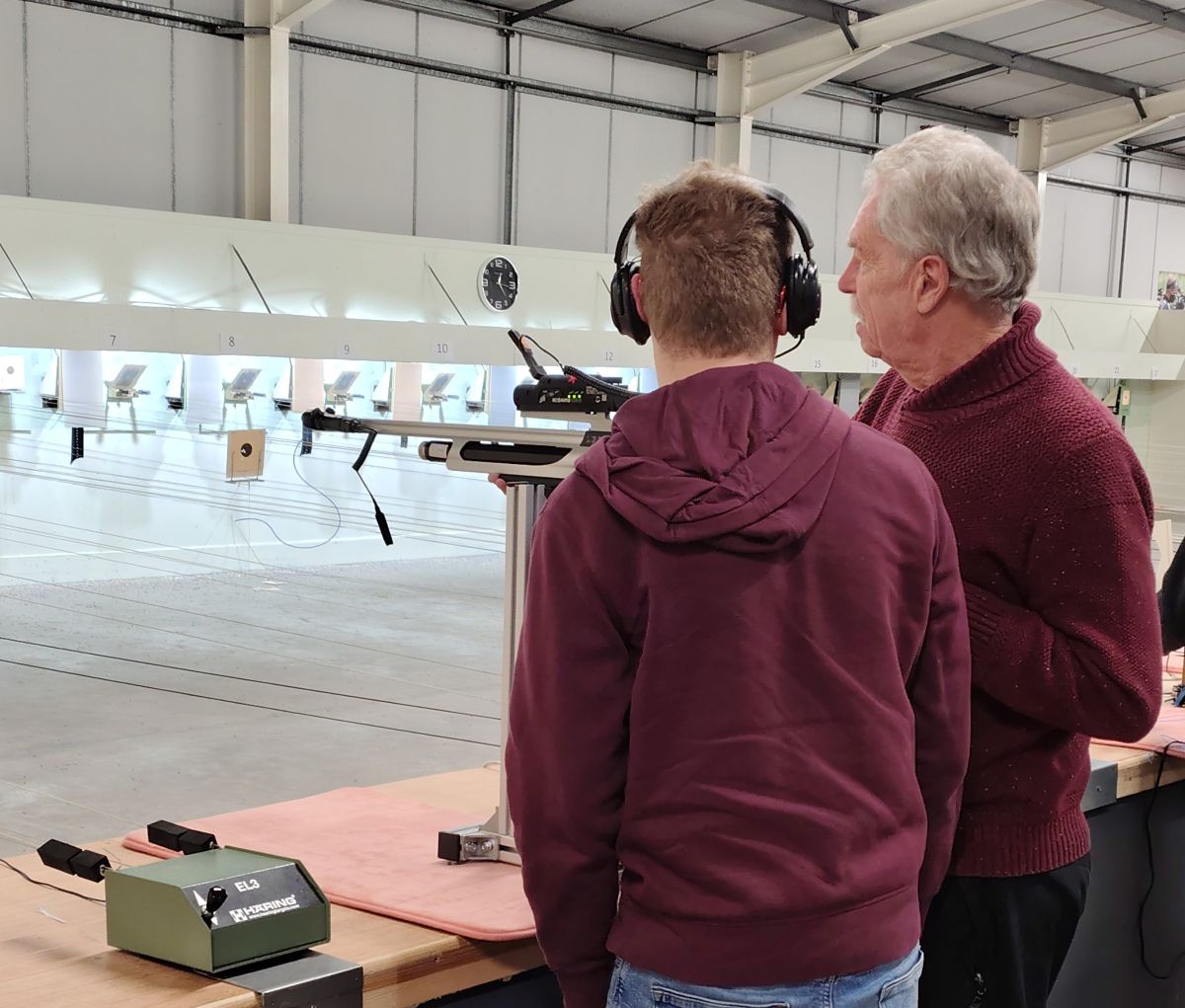 A young man talks to instructor at a rifle shooting experience