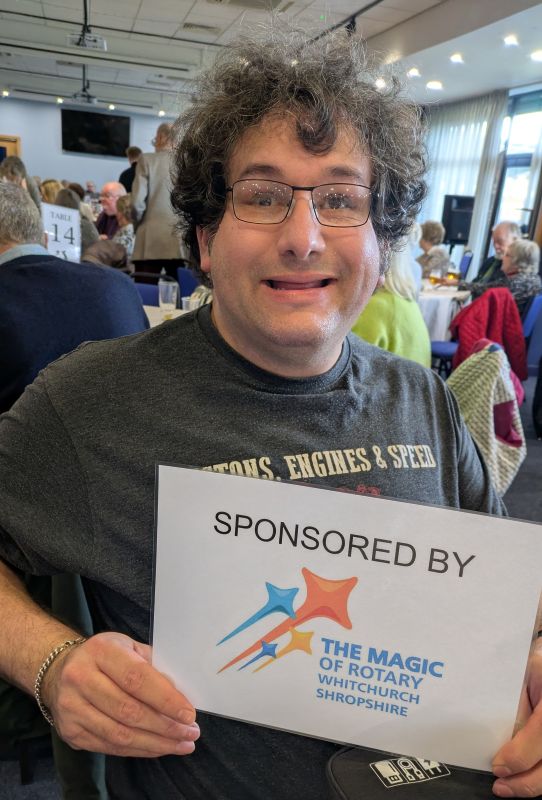 A guest holidng a Whitchurch Rotary sponsorship sign at Winter's Day Out,