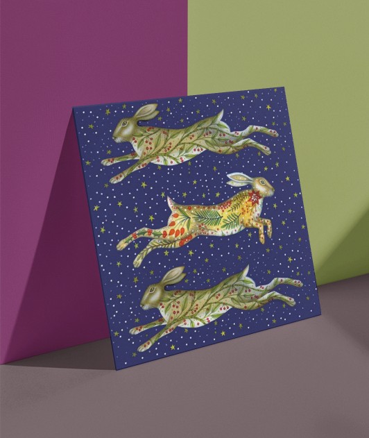 Painting of three festive leaping hares on a Christmas card