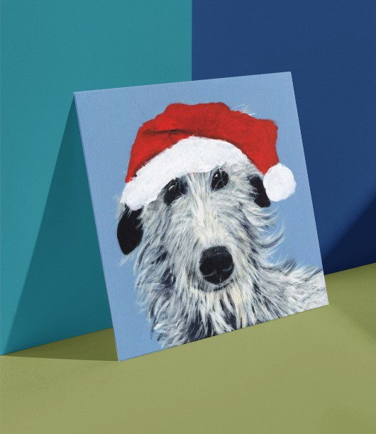 Festive Stan Christmas Card Painting of a dog wearing a festive hat on a Christmas card