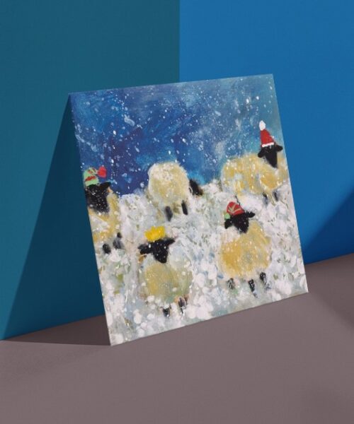 Painting of sheep wearing festive hats in a snowy scene on a Christmas card