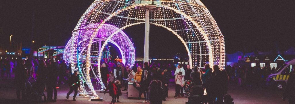 People walking through large illuminated bauble at Blackpool Illuminations