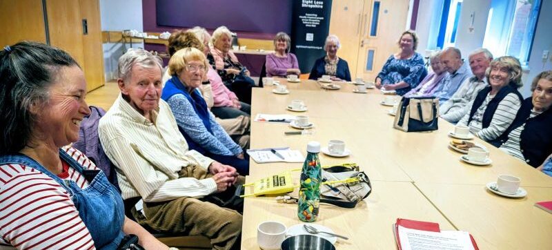 A group sight loss training session with people sitting around a large table